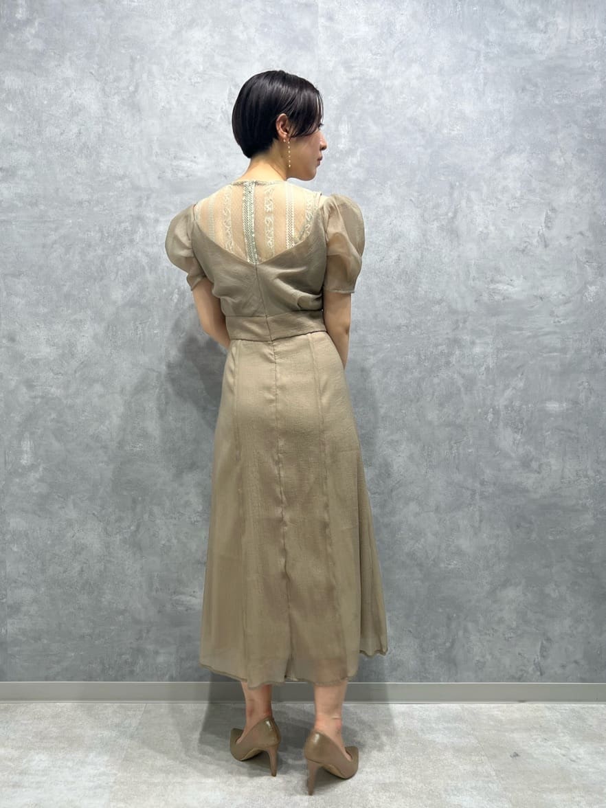 ベージュ系のドレス、ベージュ系のドレス、ゴールド系のパンプスを着用したレディースの秋コーディネートの3枚目の写真