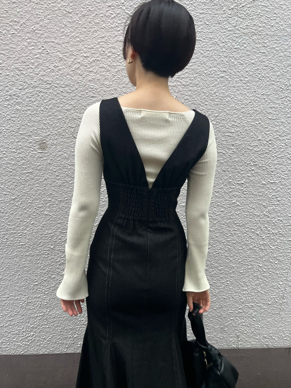 ブラック系のハンドバッグ、ブラック系のワンピース、ホワイト系のニット/セーターを着用したレディースの秋コーディネートの6枚目の写真