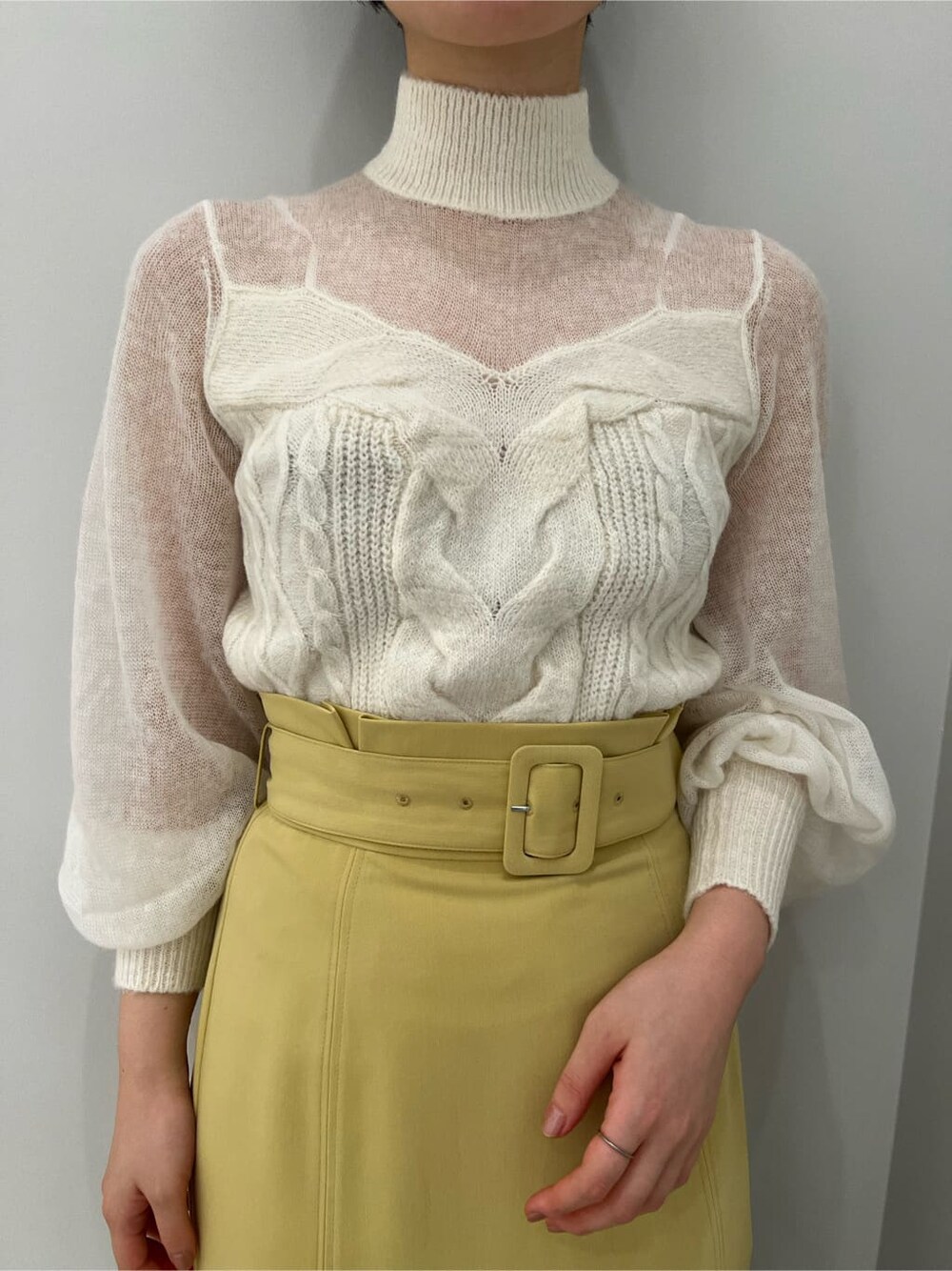 ベージュ系のその他シューズ、ホワイト系のニット/セーター、イエロー系のスカートを着用したレディースの冬コーディネートの3枚目の写真