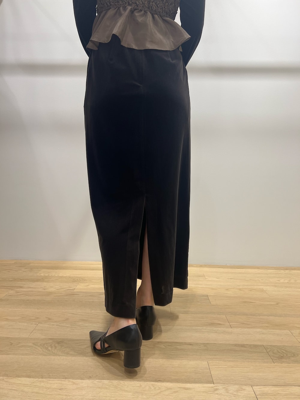 ブラック系のパンプス、ブラウン系のドレスを着用したレディースの冬コーディネートの6枚目の写真