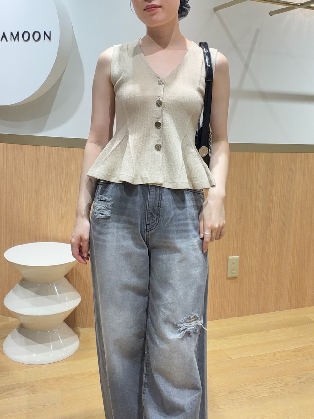 ベージュ系のニット/セーター、グレー系のデニムパンツ、ブラック系のサンダルを着用したレディースの春コーディネートの3枚目の写真