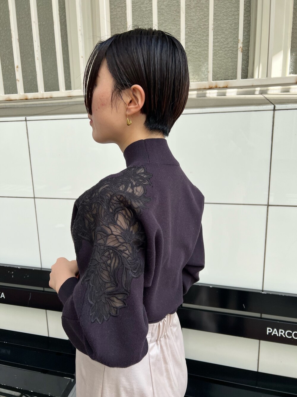 レッド系のブーツ、グレー系のスカート、グレー系のニット/セーターを着用したレディースの秋コーディネートの7枚目の写真