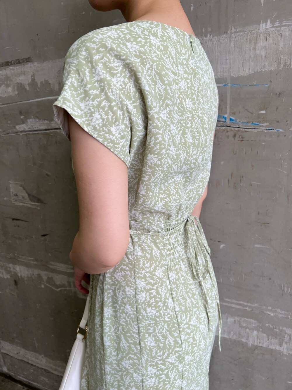 ベージュ系のサンダル、グリーン系のワンピース、ホワイト系のハンドバッグを着用したレディースの夏コーディネートの4枚目の写真