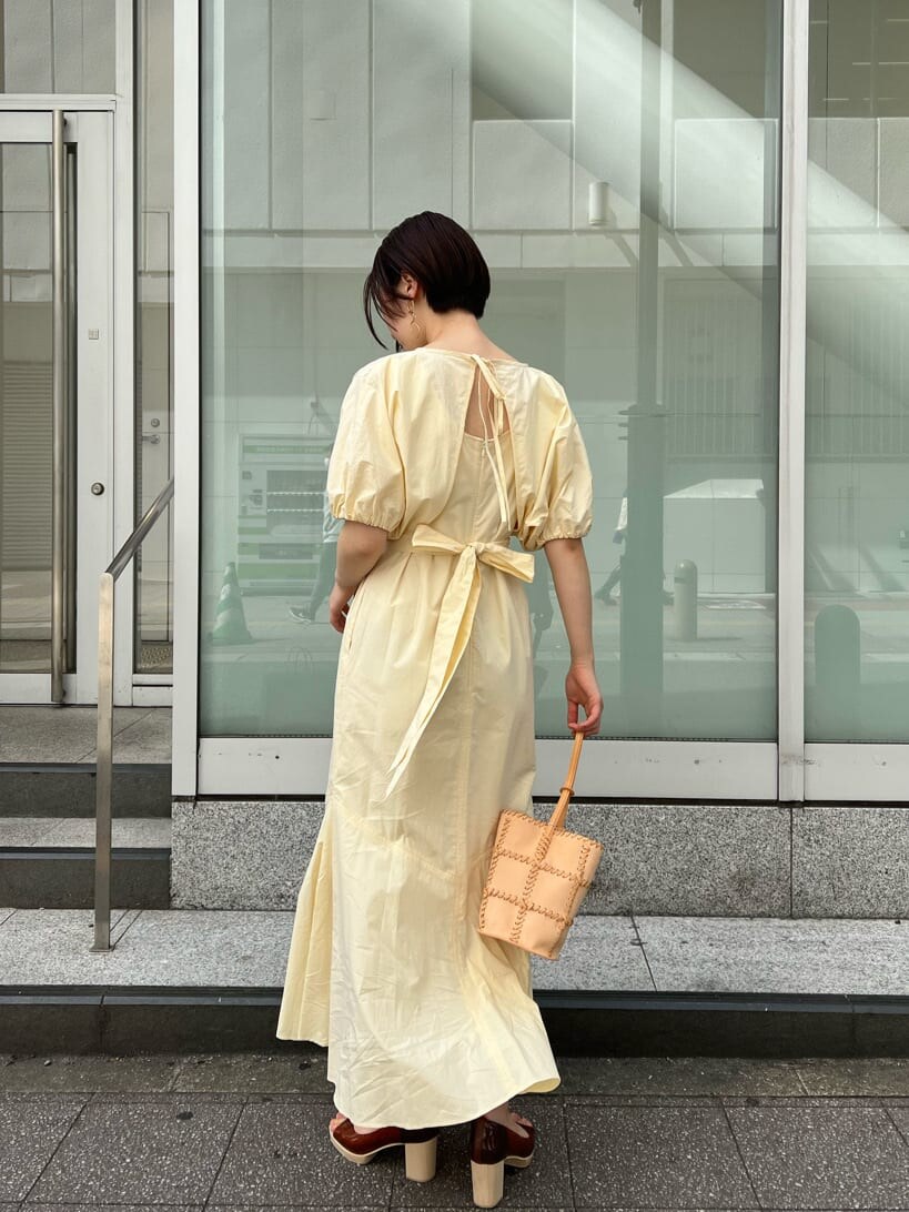 ブルー系のトレンチコート、ブラック系のワンピース、ブラウン系のパンプスを着用したレディースの春コーディネートの6枚目の写真