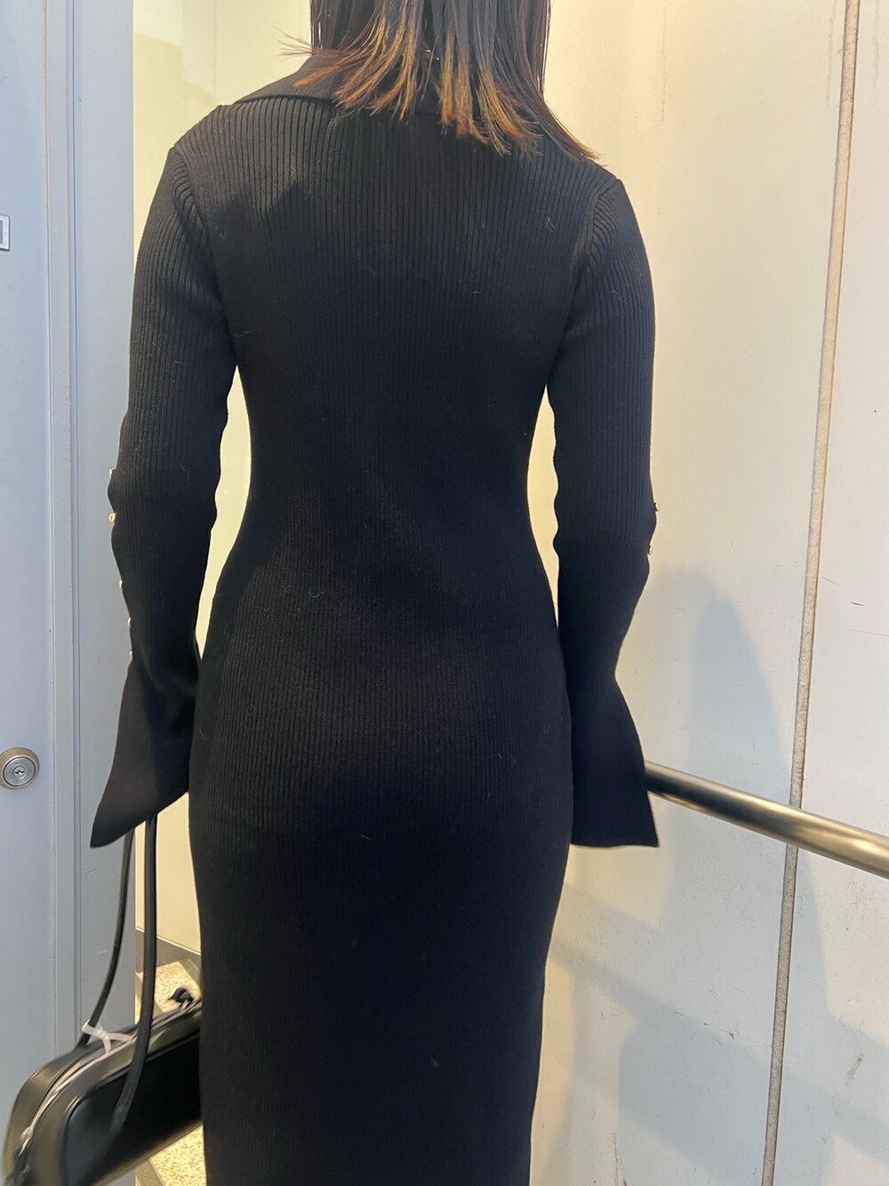 ブラック系のワンピース、ブラウン系のカーディガン/ボレロ、ブラック系のブーツを着用したレディースの冬コーディネートの7枚目の写真