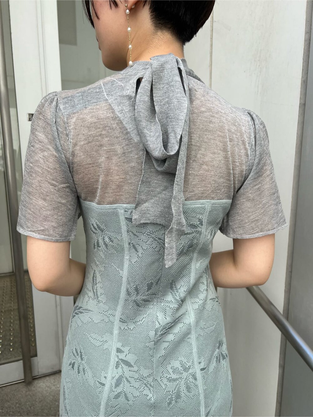 ゴールド系のクラッチバッグ、ゴールド系のパンプス、ブルー系のドレスを着用したレディースの秋コーディネートの7枚目の写真