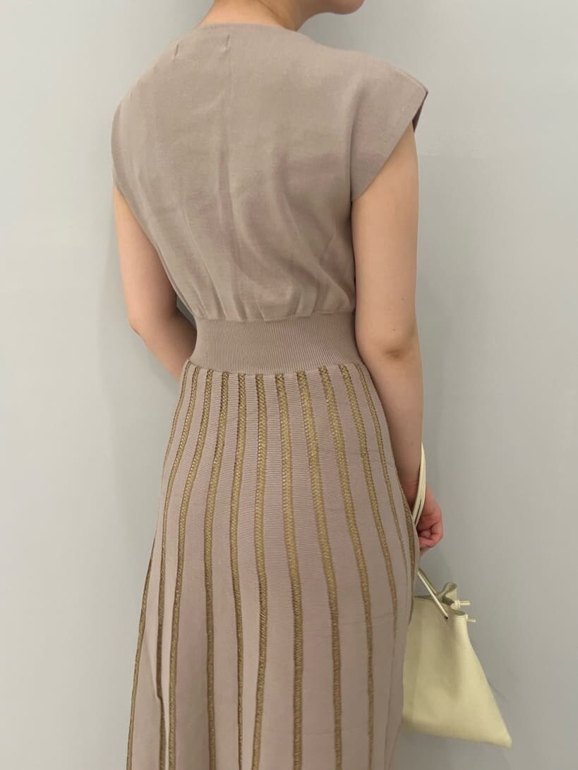 ホワイト系のハンドバッグ、ブラウン系のパンプス、ベージュ系のワンピースを着用したレディースの夏コーディネートの6枚目の写真