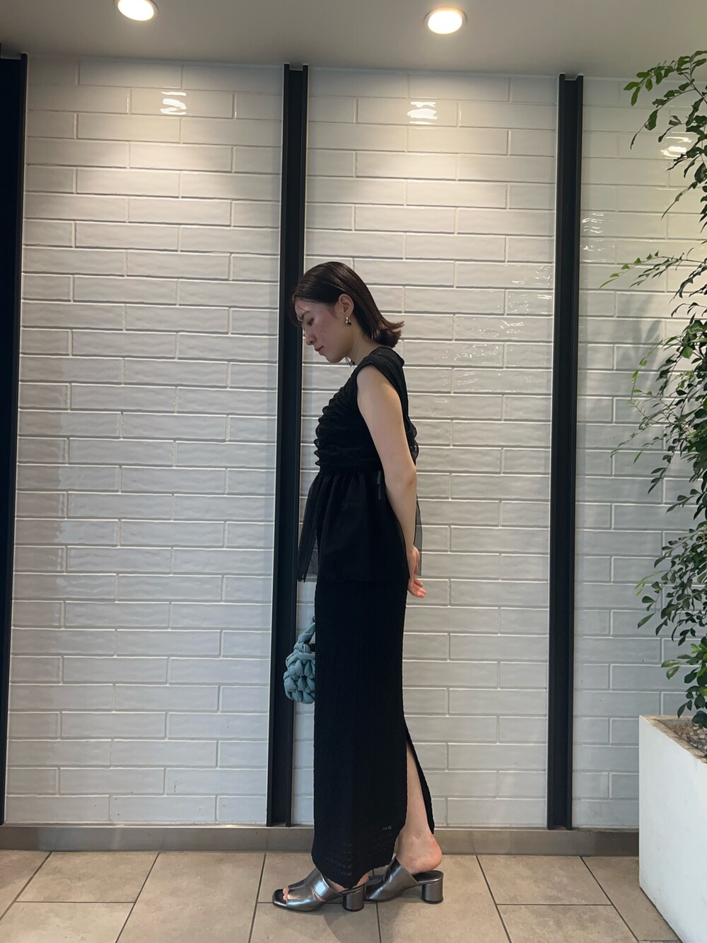 その他のサンダル、ブラック系のワンピース、ブルー系のハンドバッグを着用したレディースの夏コーディネートの2枚目の写真