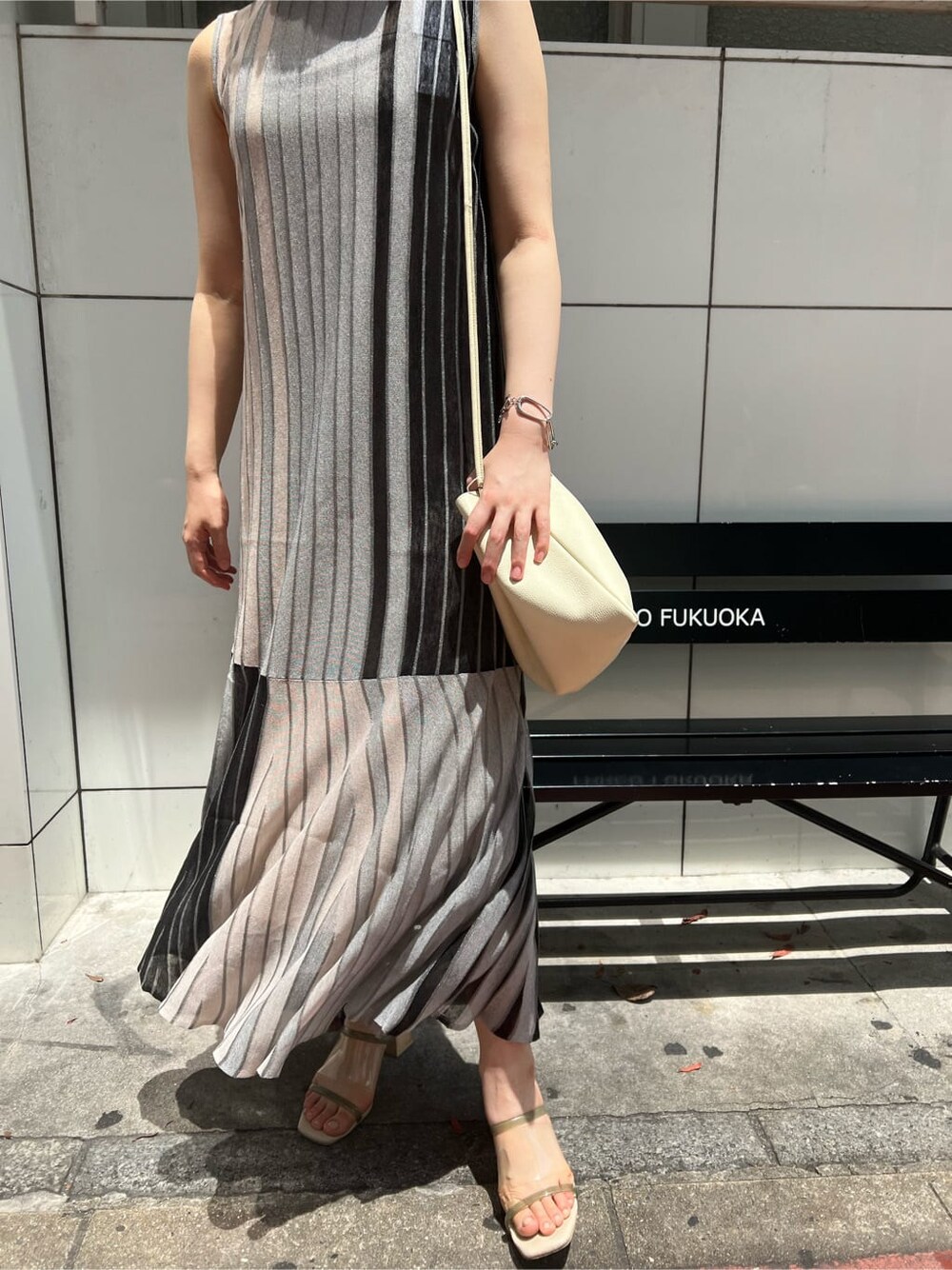 ホワイト系のハンドバッグ、グリーン系のサンダル、ブラック系のワンピースを着用したレディースの夏コーディネートの5枚目の写真