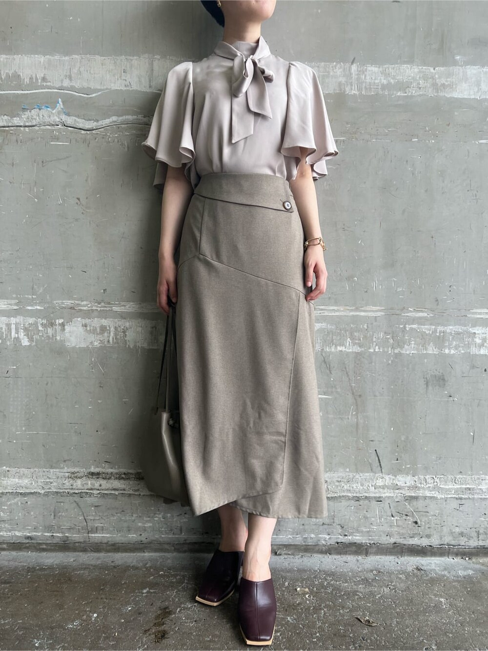 ベージュ系のハンドバッグ、レッド系のサンダル、ベージュ系のスカートを着用したレディースの夏コーディネートの7枚目の写真