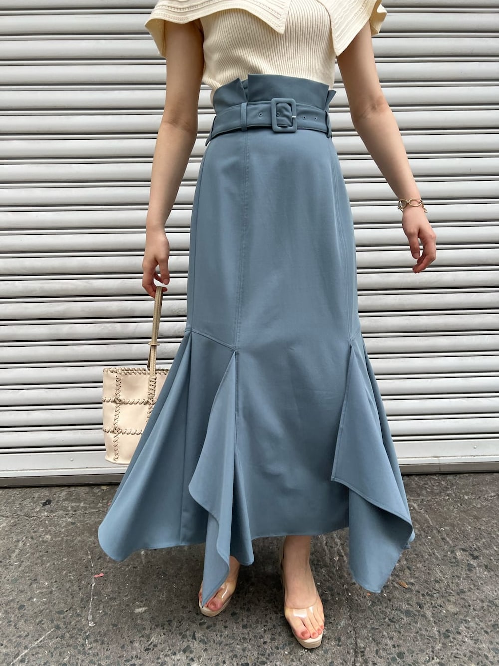 その他のパンプス、ホワイト系のショルダーバッグ、ブルー系のスカートを着用したレディースの春コーディネートの7枚目の写真