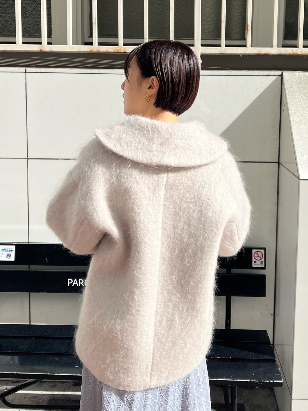 ホワイト系のショルダーバッグ、ベージュ系のブーツ、ベージュ系のその他アウターを着用したレディースの冬コーディネートの5枚目の写真