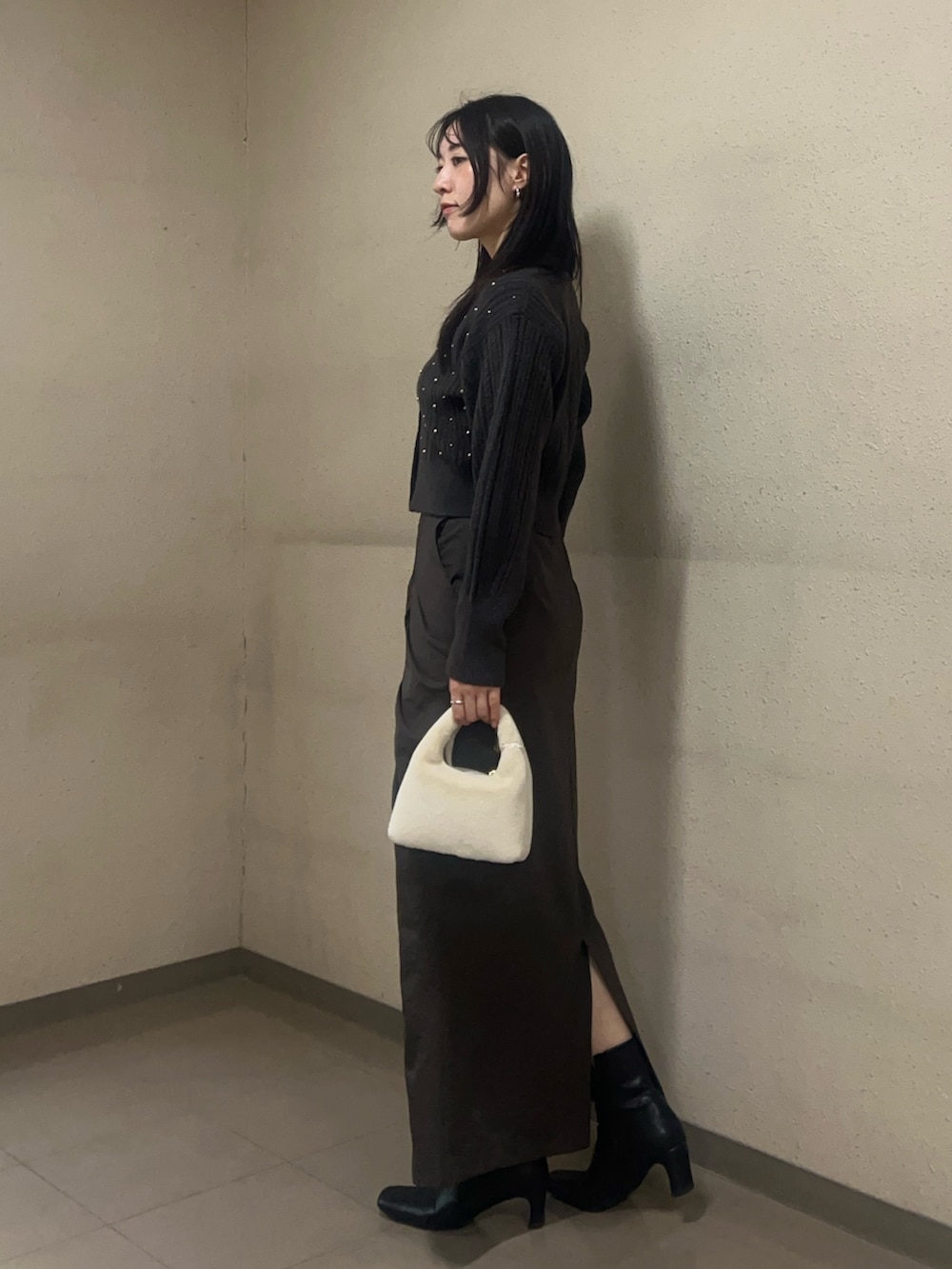 ブラック系のブーツ、グレー系のニット/セーター、ブラウン系のスカートを着用したレディースの秋コーディネートの2枚目の写真