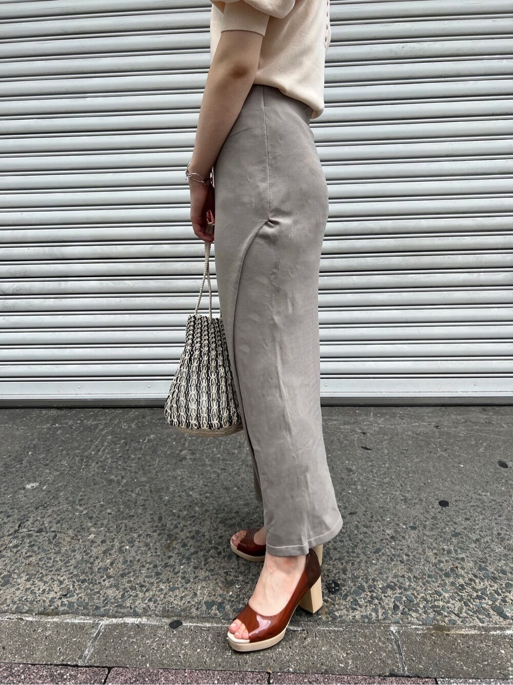 ブラウン系のパンプス、ホワイト系のニット/セーター、ホワイト系のハンドバッグを着用したレディースの夏コーディネートの8枚目の写真