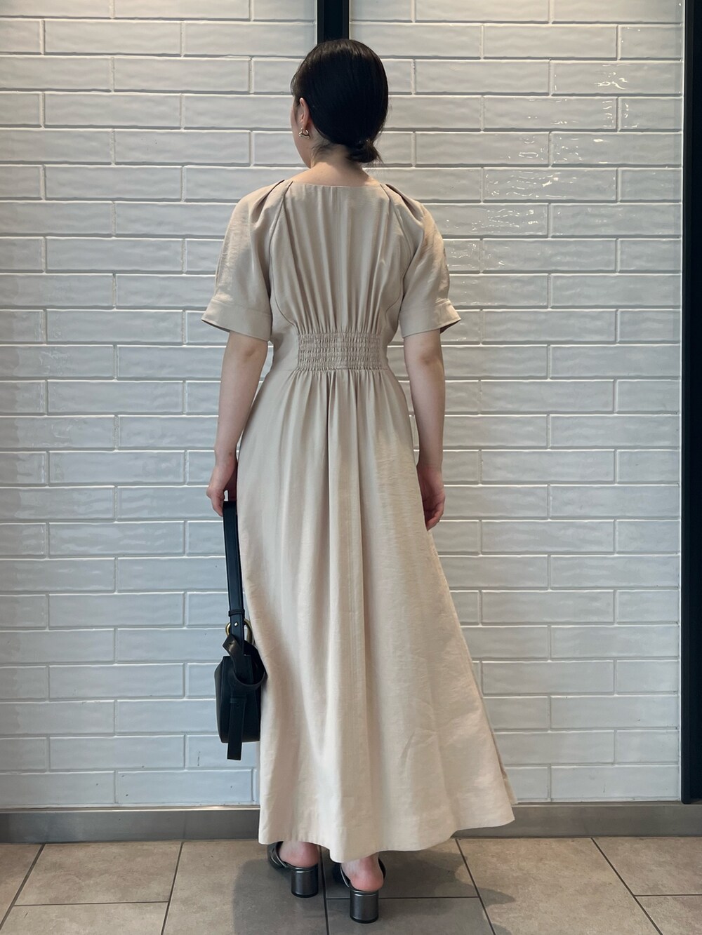 ベージュ系のワンピース、ブラック系のショルダーバッグ、その他のサンダルを着用したレディースの夏コーディネートの3枚目の写真