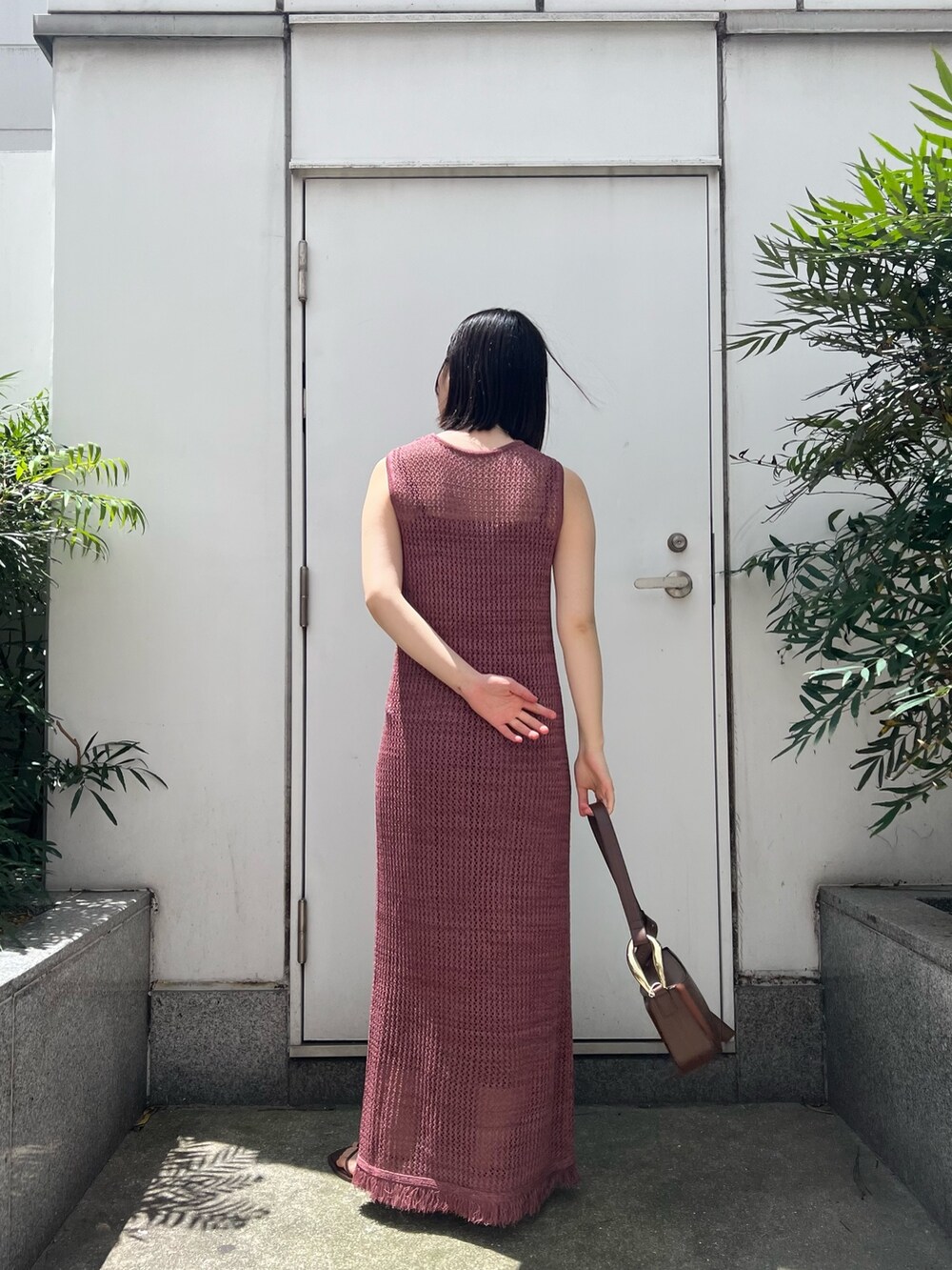 ブラウン系のショルダーバッグ、ホワイト系のシャツ/ブラウス、ピンク系のワンピースを着用したレディースの春コーディネートの4枚目の写真