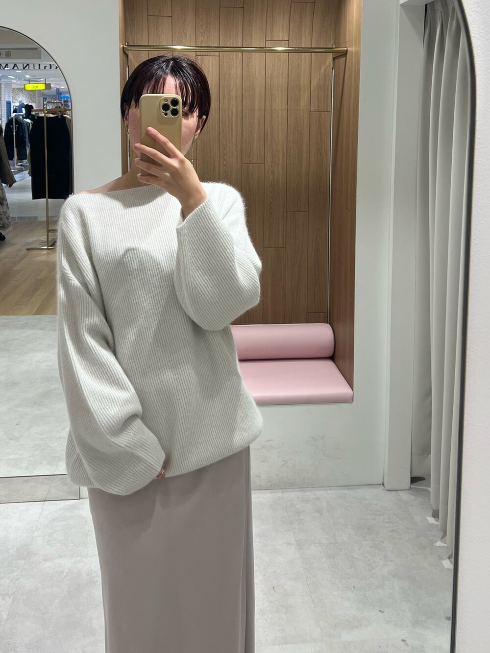 ベージュ系のスニーカー、ホワイト系のニット/セーター、ホワイト系のスカートを着用したレディースの秋コーディネートの2枚目の写真