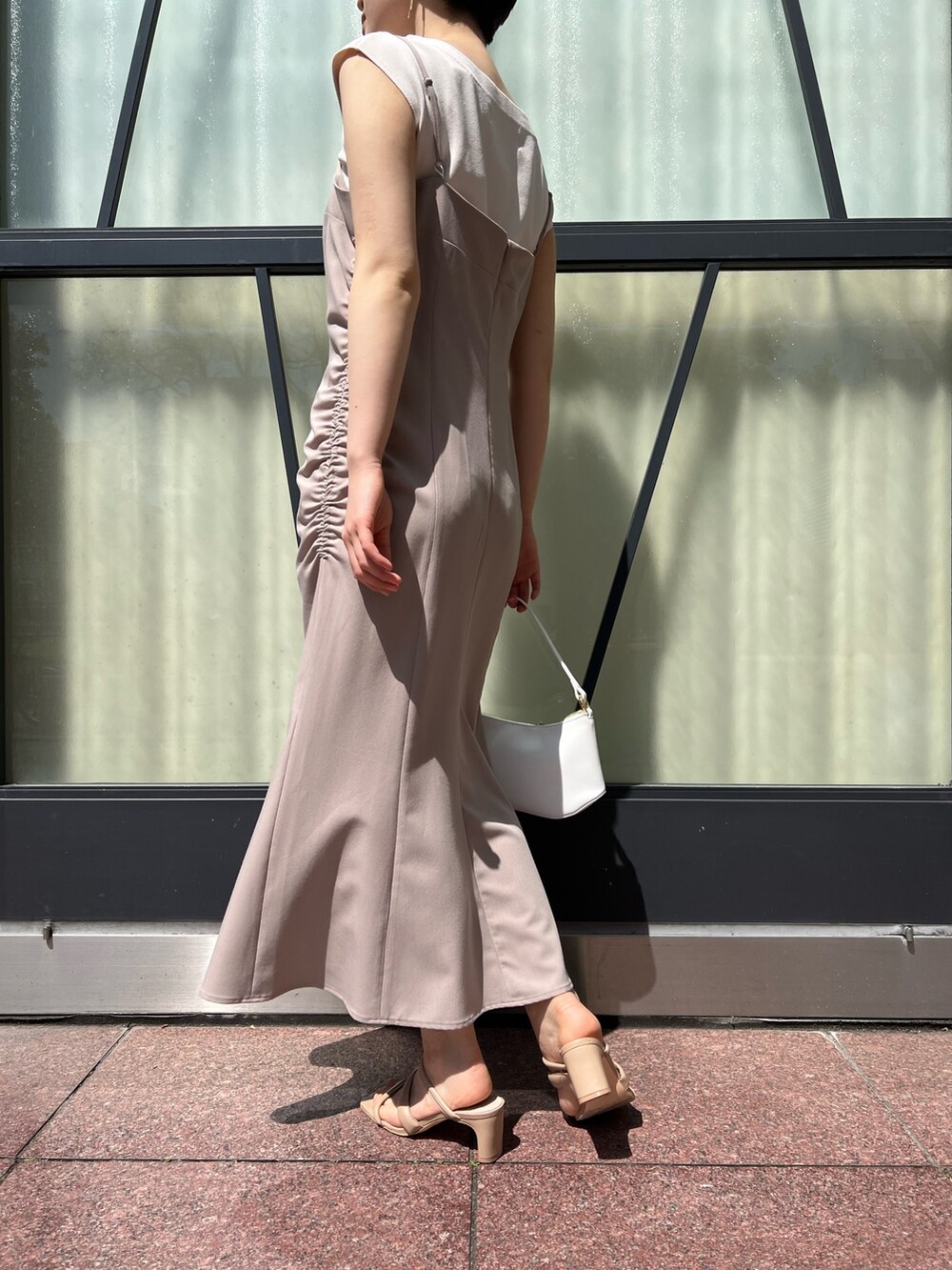 ベージュ系のワンピース、ピンク系のテーラードジャケット、ホワイト系のハンドバッグを着用したレディースの春コーディネートの9枚目の写真