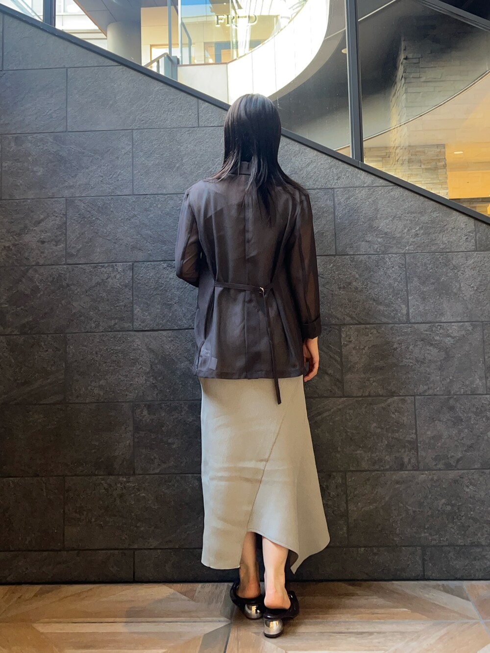 グリーン系のワンピース、ブラウン系のパンプス、ブラウン系のテーラードジャケットを着用したレディースの夏コーディネートの3枚目の写真