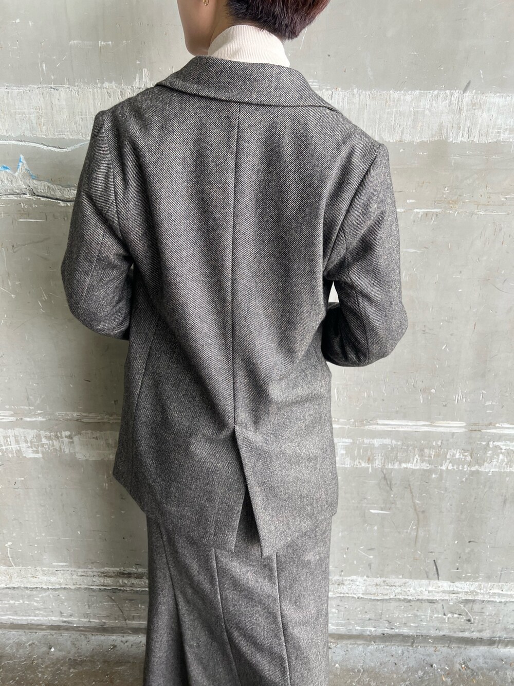 ブラウン系のスカート、ブラウン系のテーラードジャケット、ホワイト系のハンドバッグを着用したレディースの秋コーディネートの6枚目の写真