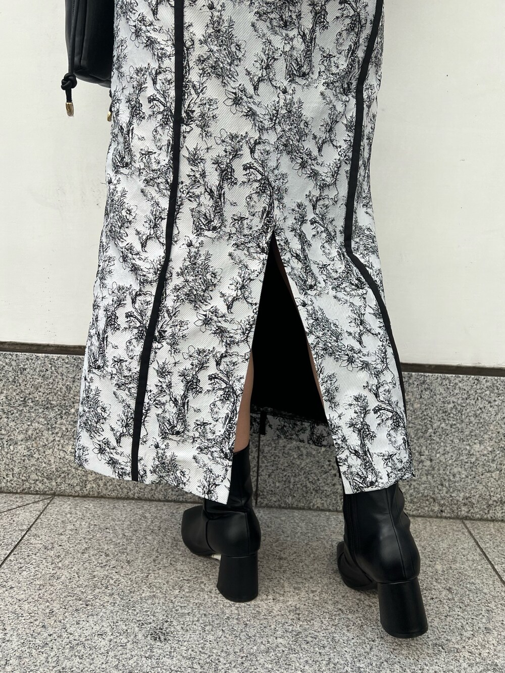 ブラック系のブーツ、ブラック系のスカート、グレー系のカーディガン/ボレロを着用したレディースの秋コーディネートの10枚目の写真