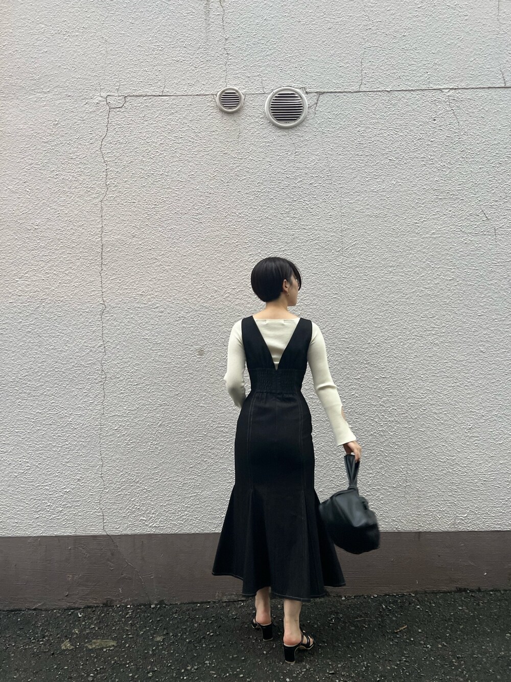 ブラック系のハンドバッグ、ブラック系のワンピース、ホワイト系のニット/セーターを着用したレディースの秋コーディネートの3枚目の写真