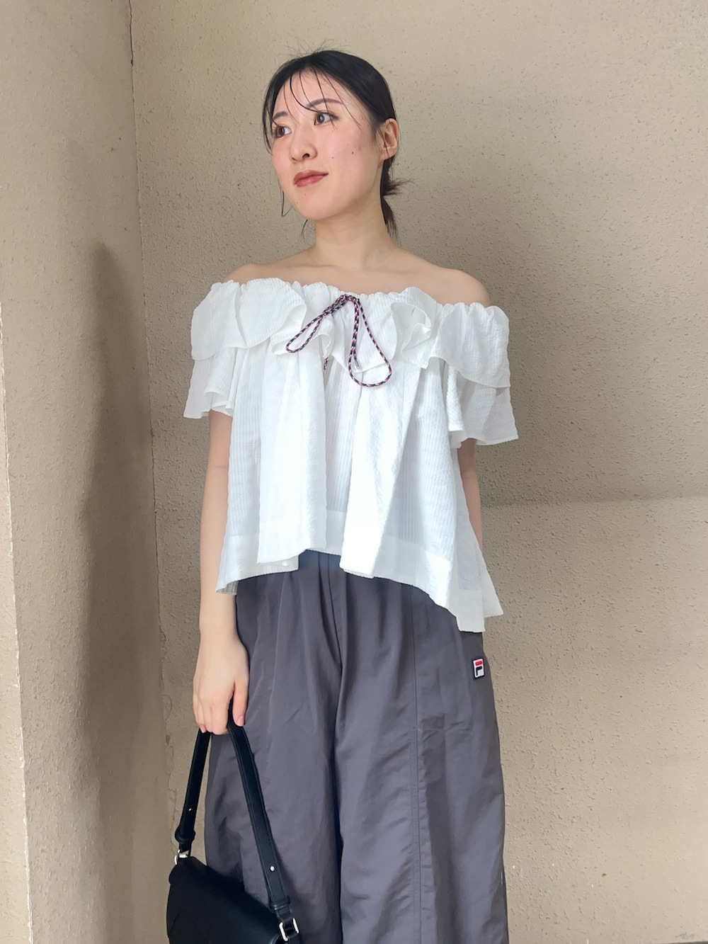 ホワイト系のシャツ/ブラウス、グレー系のその他パンツ、ブラック系のパンプスを着用したレディースの春コーディネートの3枚目の写真