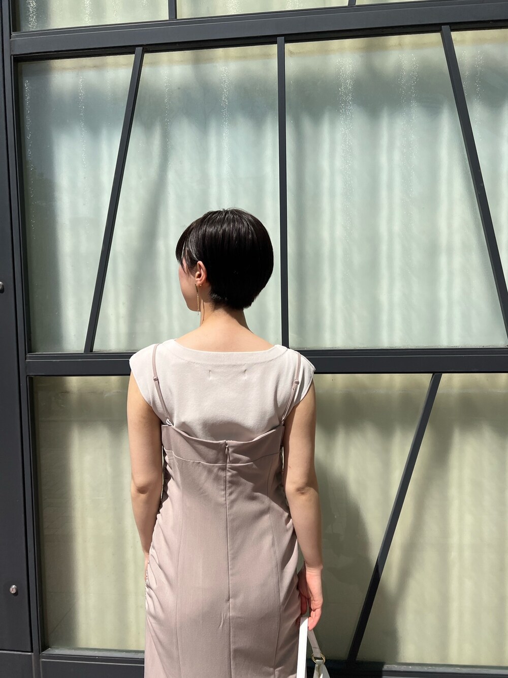 ベージュ系のワンピース、ピンク系のテーラードジャケット、ホワイト系のハンドバッグを着用したレディースの春コーディネートの6枚目の写真