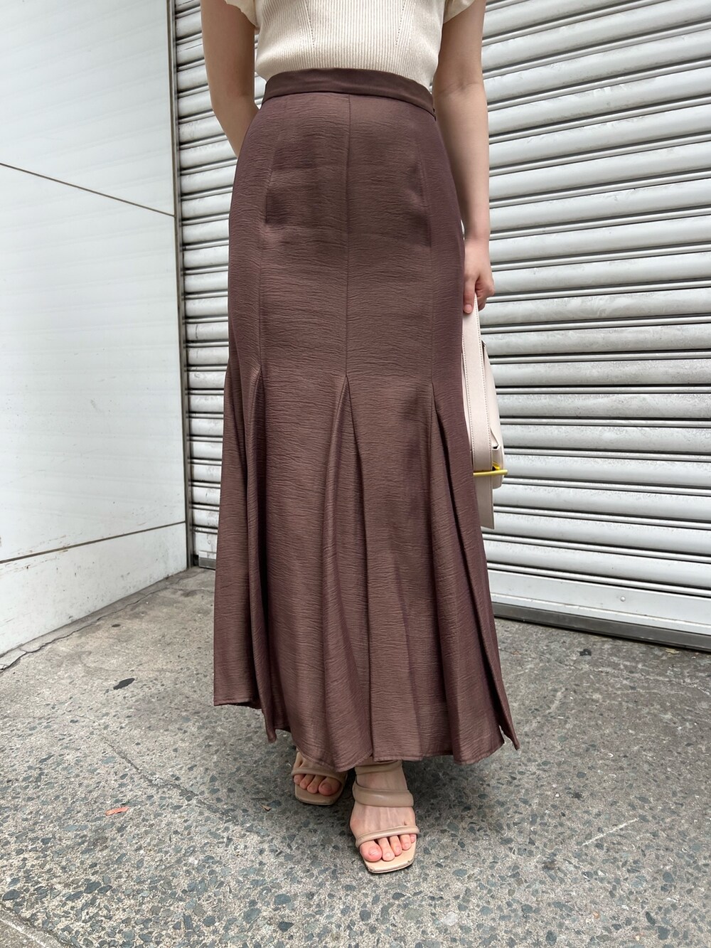 ベージュ系のサンダル、ブラウン系のスカート、ホワイト系のハンドバッグを着用したレディースの夏コーディネートの7枚目の写真