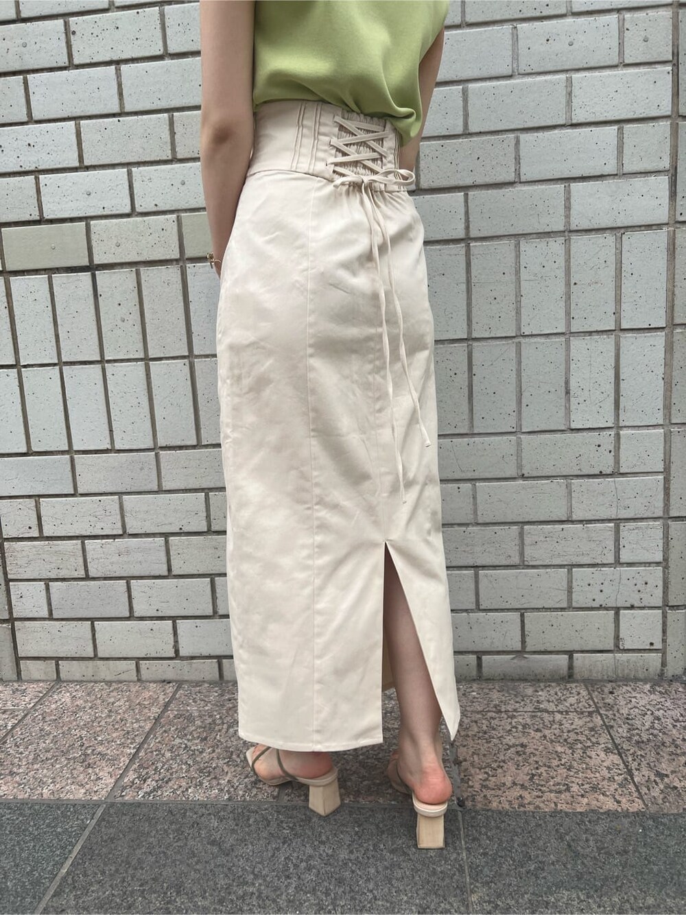 ホワイト系のハンドバッグ、グリーン系のサンダル、ホワイト系のスカートを着用したレディースの春コーディネートの8枚目の写真