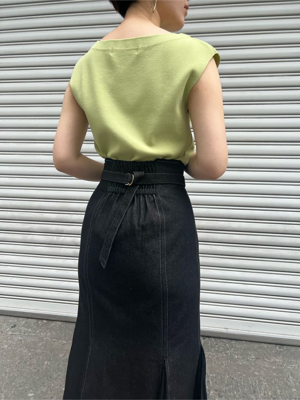 ブルー系のスカート、ベージュ系のサンダル、イエロー系のニット/セーターを着用したレディースの春コーディネートの7枚目の写真