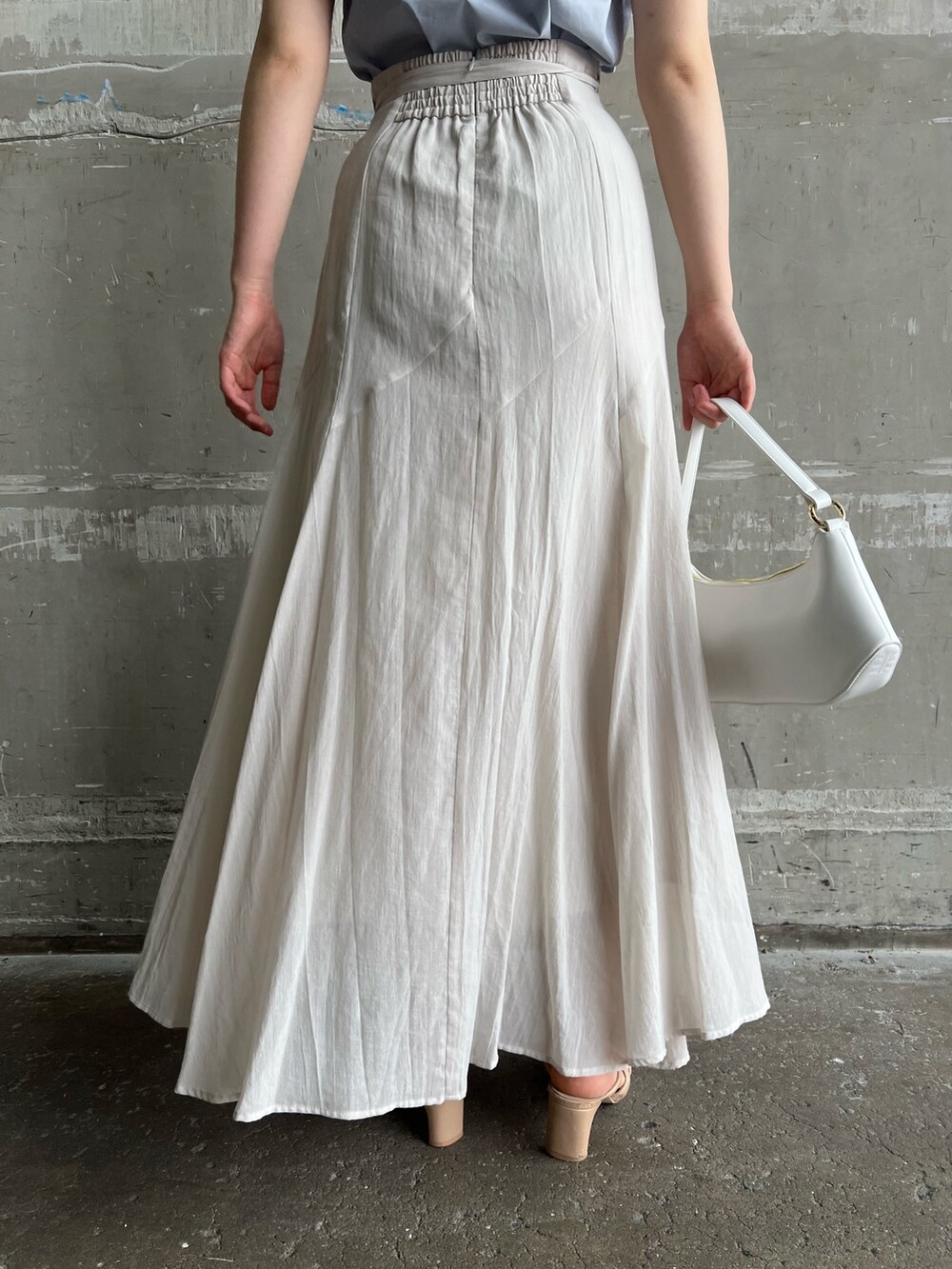 ベージュ系のサンダル、ホワイト系のハンドバッグ、グレー系のスカートを着用したレディースの夏コーディネートの7枚目の写真