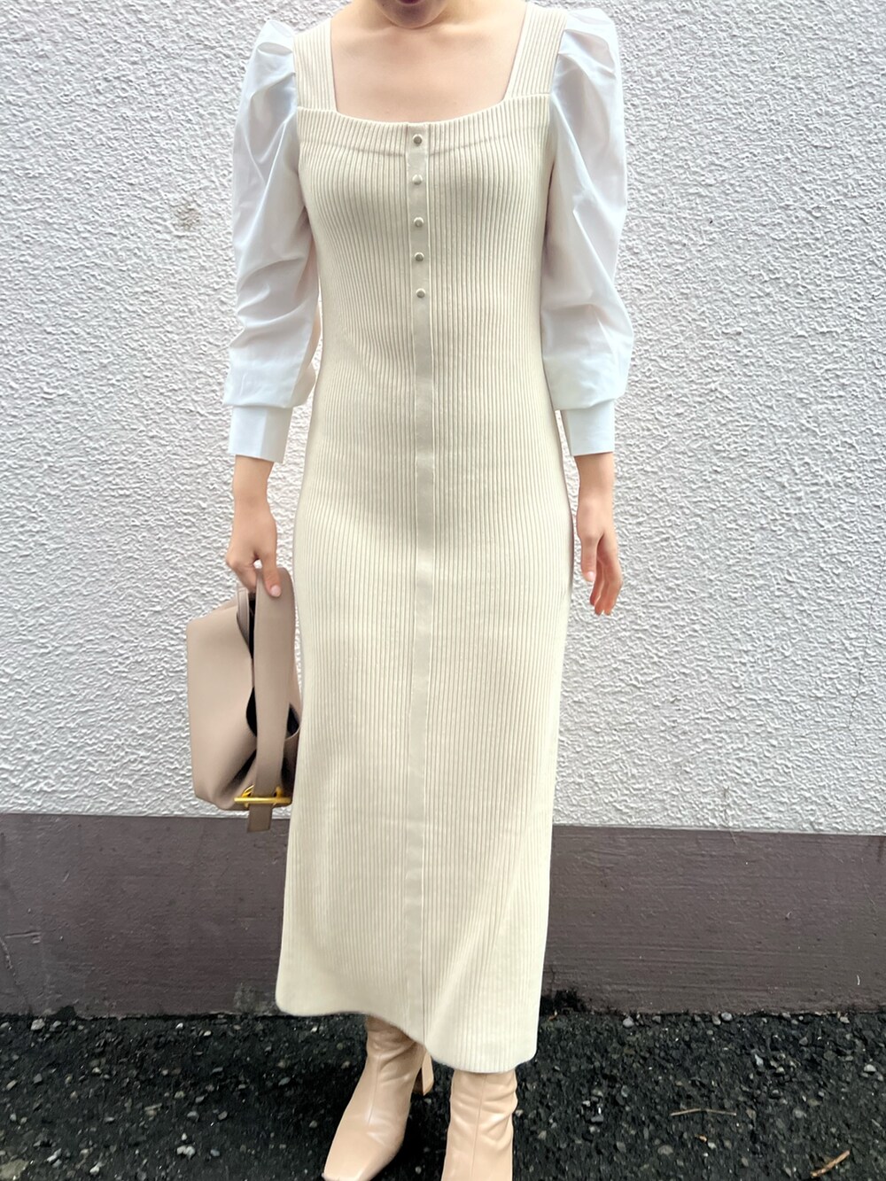 ベージュ系のハンドバッグ、ベージュ系のブーツ、ホワイト系のワンピースを着用したレディースの秋コーディネートの5枚目の写真