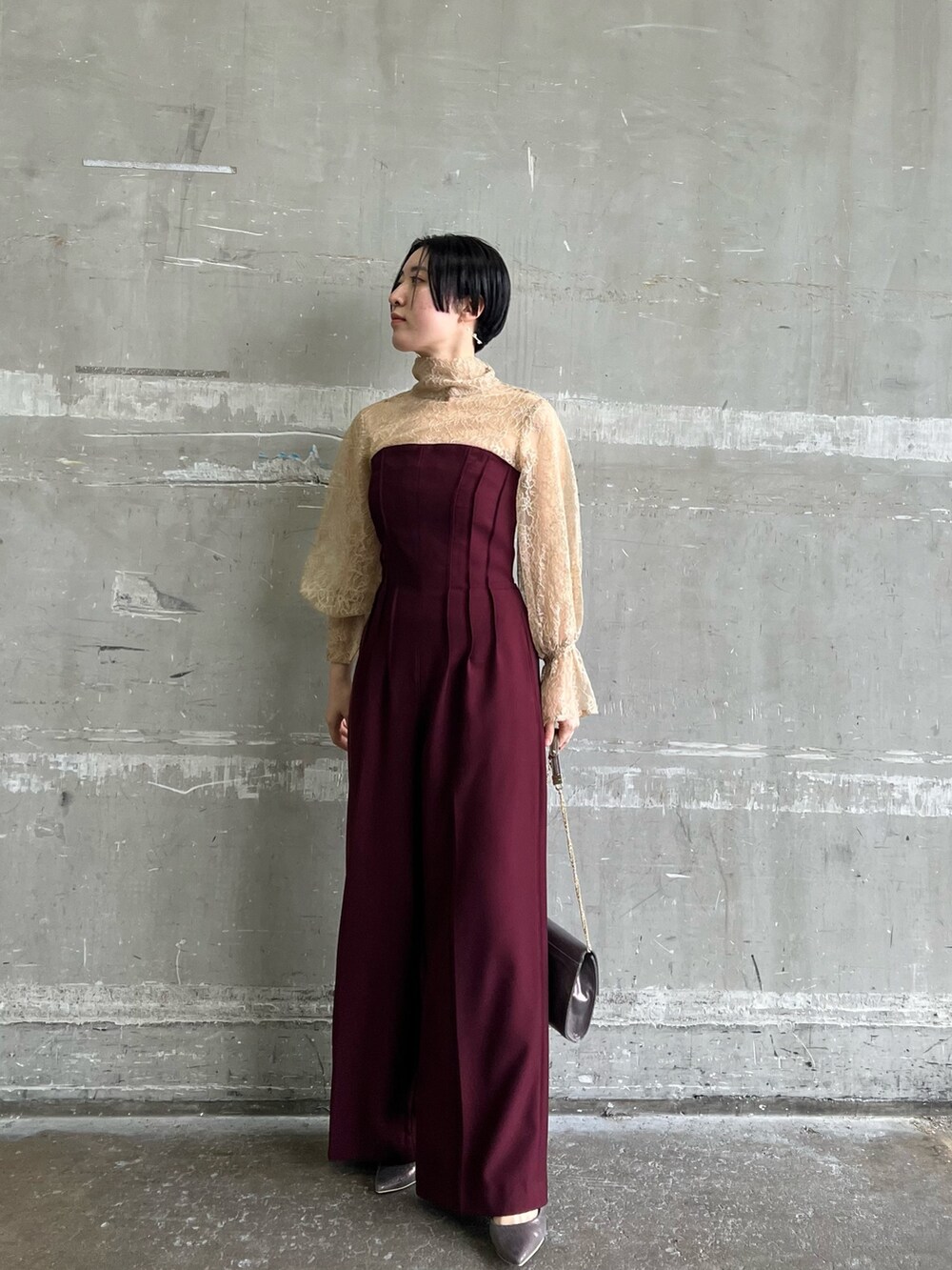 ホワイト系のノーカラーコート、シルバー系のハンドバッグ、シルバー系のパンプスを着用したレディースの冬コーディネートの3枚目の写真