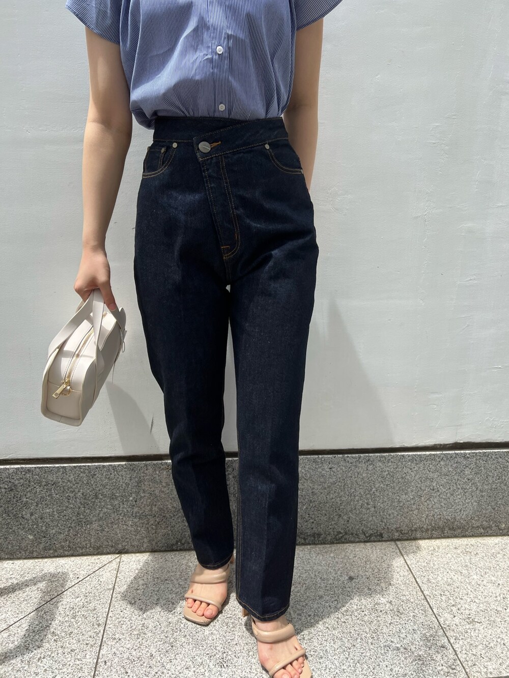 ベージュ系のサンダル、ホワイト系のショルダーバッグ、ブルー系のデニムパンツを着用したレディースの夏コーディネートの9枚目の写真