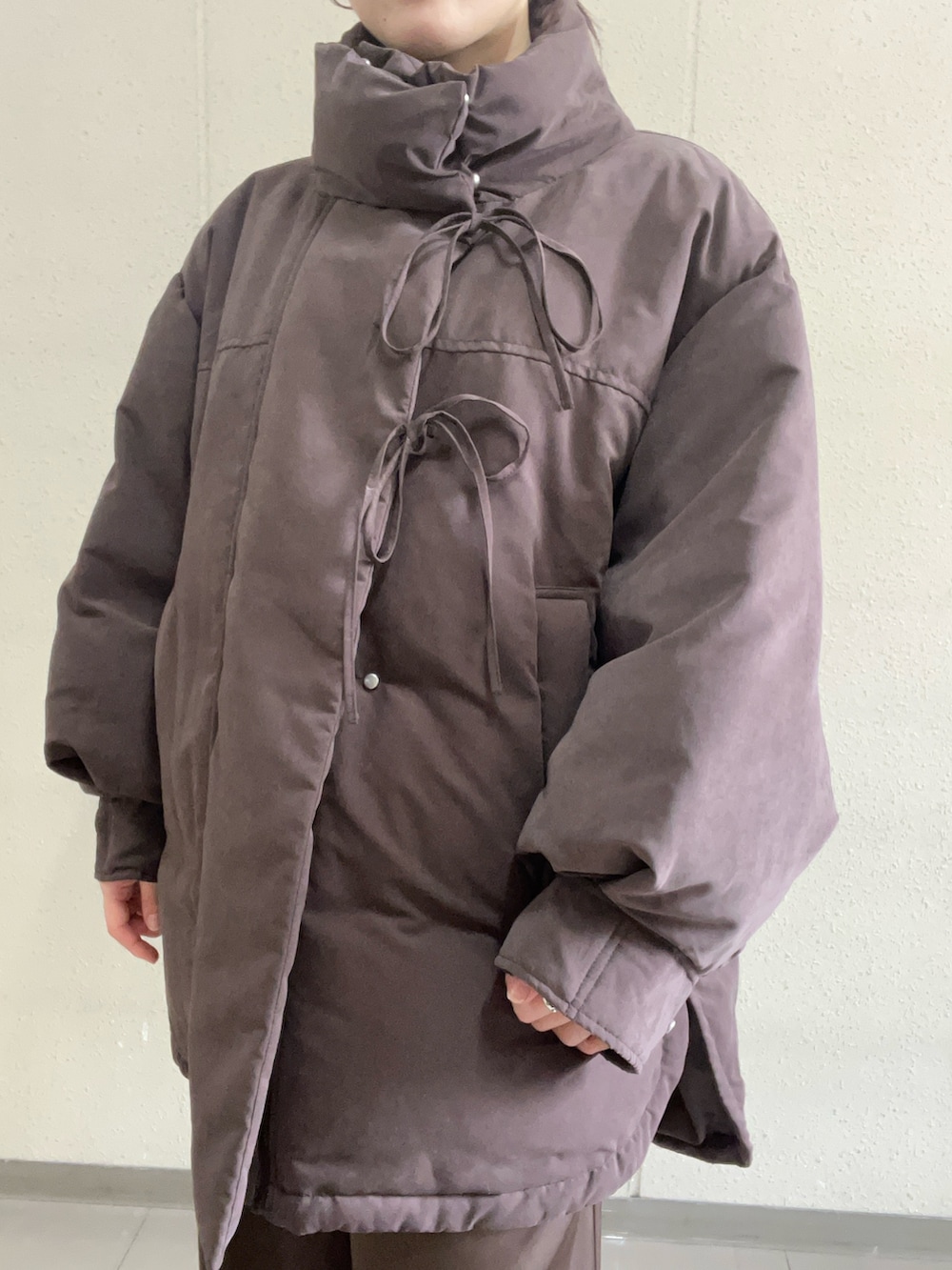 ベージュ系のニット/セーター、ブラウン系のダウンジャケット/コート、ブラウン系のその他パンツを着用したレディースの冬コーディネートの5枚目の写真