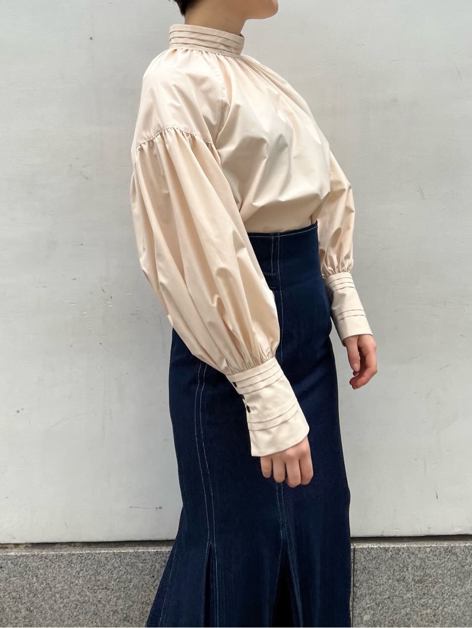 ベージュ系のシャツ/ブラウス、ベージュ系のブーツ、ブルー系のスカートを着用したレディースの春コーディネートの8枚目の写真