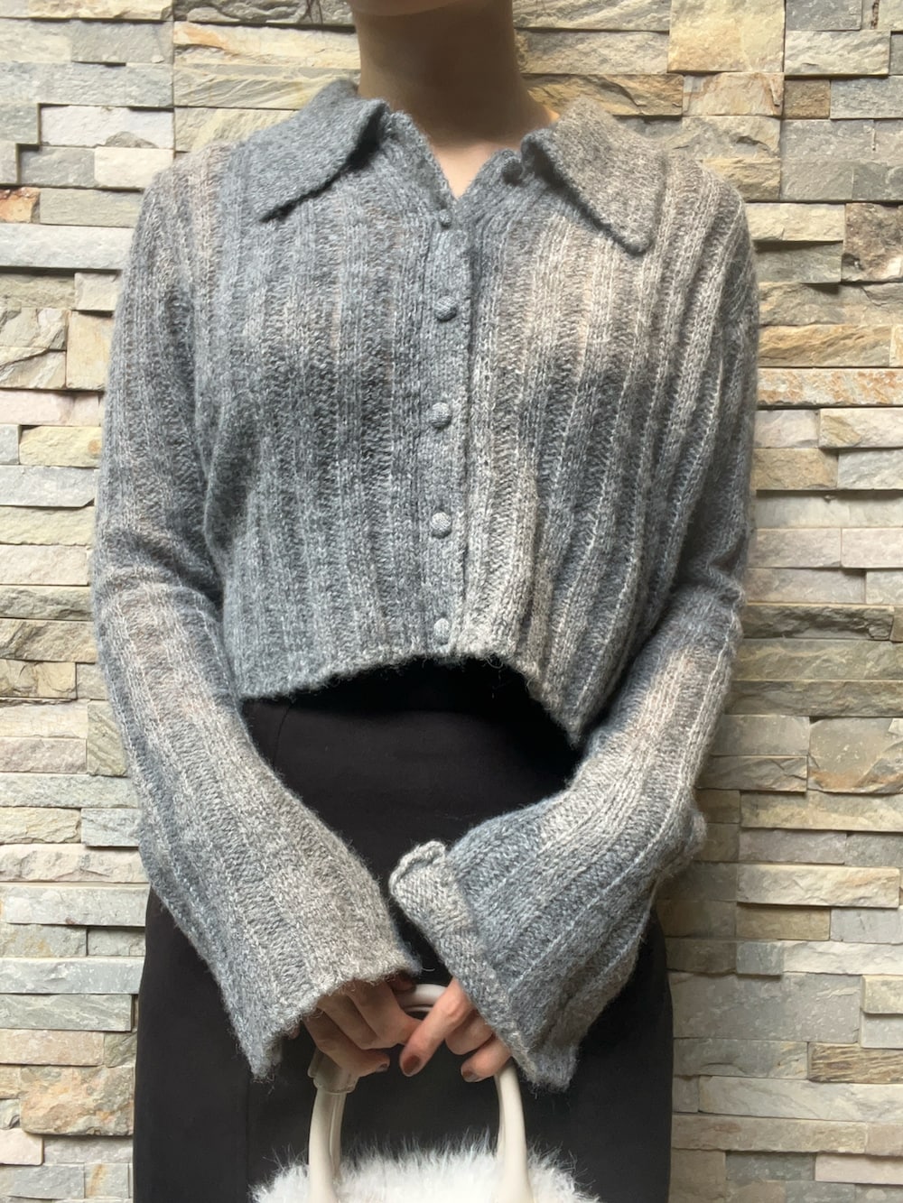 ブラック系のスカート、グレー系のニット/セーター、ブラウン系のパンプスを着用したレディースの秋コーディネートの4枚目の写真