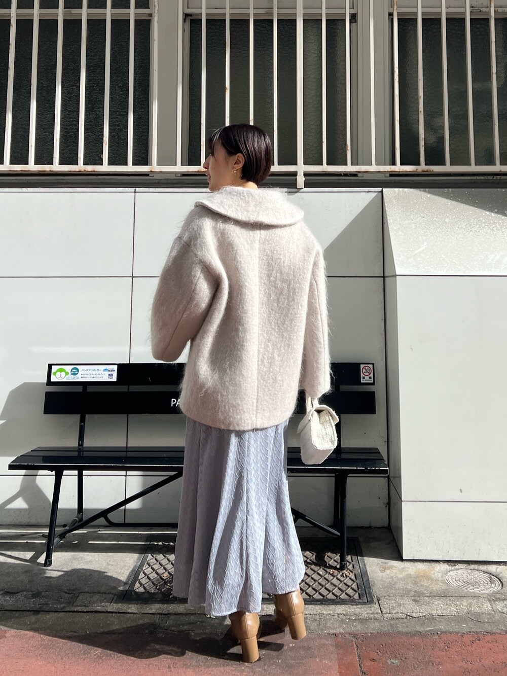 ホワイト系のショルダーバッグ、ベージュ系のブーツ、ベージュ系のその他アウターを着用したレディースの冬コーディネートの3枚目の写真