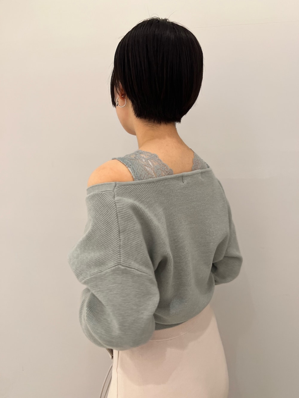 レッド系のブーツ、ホワイト系のハンドバッグ、ホワイト系のスカートを着用したレディースの冬コーディネートの5枚目の写真