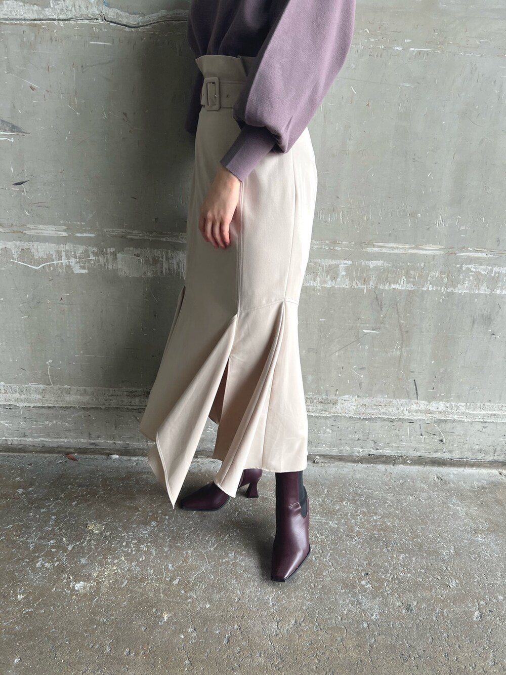 ホワイト系のノーカラーコート、ベージュ系のニット/セーター、ブラウン系のスカートを着用したレディースの秋コーディネートの10枚目の写真