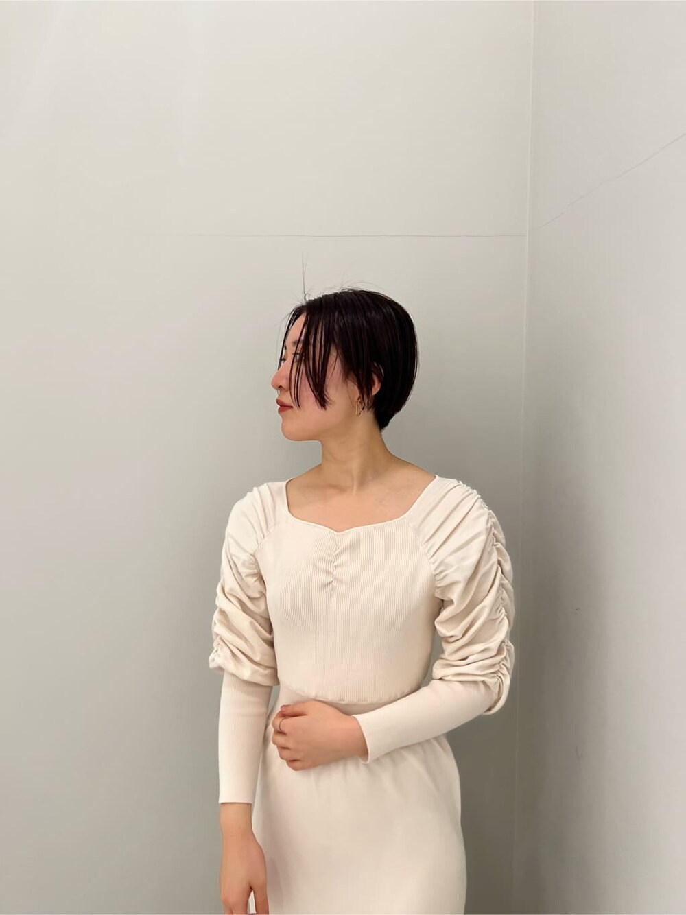 ベージュ系のブーツ、ホワイト系のワンピースを着用したレディースの冬コーディネートの4枚目の写真