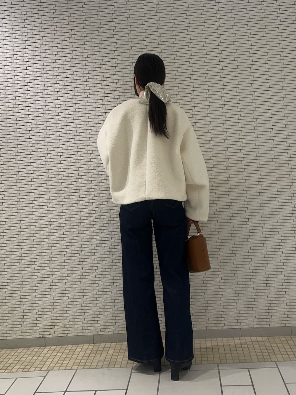 ブルー系のデニムパンツ、ホワイト系のブルゾン、ピンク系のニット/セーターを着用したレディースの冬コーディネートの3枚目の写真