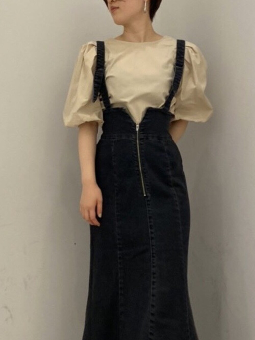 ベージュ系のシャツ/ブラウス、ブラック系のスカート、ベージュ系のブーツを着用したレディースの夏コーディネートの7枚目の写真