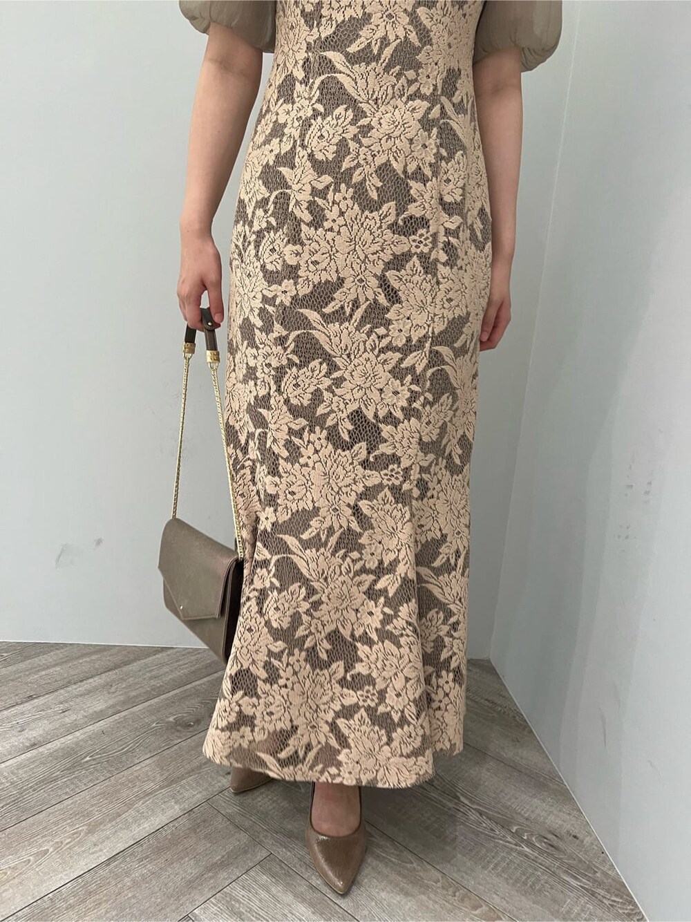 ゴールド系のクラッチバッグ、ゴールド系のパンプス、ベージュ系のドレスを着用したレディースの夏コーディネートの10枚目の写真