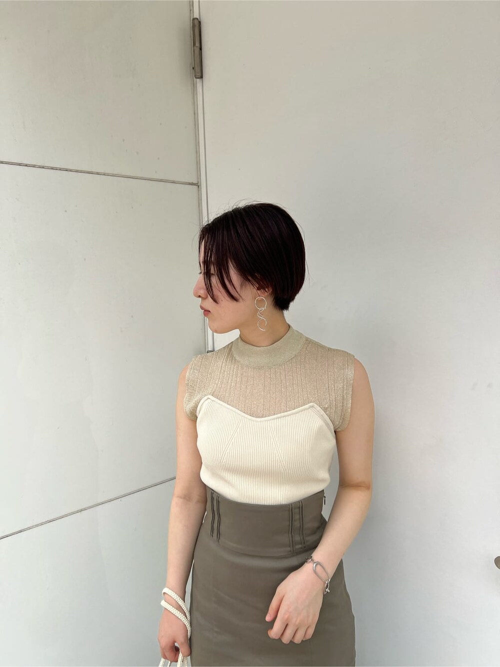 グリーン系のサンダル、ベージュ系のスカート、ホワイト系のニット/セーターを着用したレディースの夏コーディネートの7枚目の写真