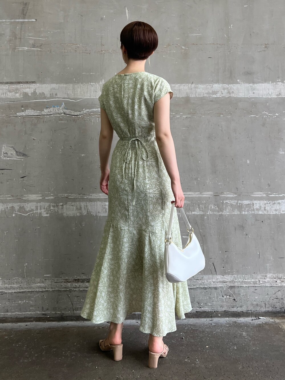 ベージュ系のサンダル、グリーン系のワンピース、ホワイト系のハンドバッグを着用したレディースの夏コーディネートの2枚目の写真