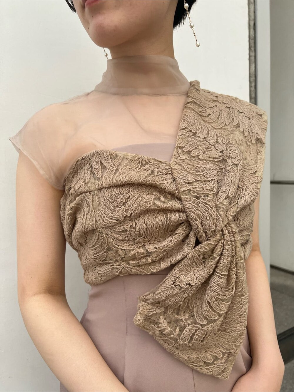 ゴールド系のクラッチバッグ、ベージュ系のパンツドレス、ブラック系のその他トップスを着用したレディースの夏コーディネートの5枚目の写真