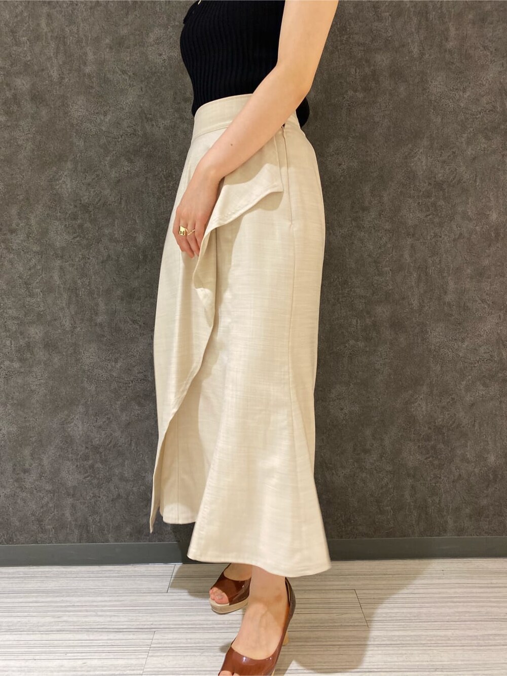 ブラウン系のパンプス、ホワイト系のスカート、ブラック系のニット/セーターを着用したレディースの夏コーディネートの7枚目の写真