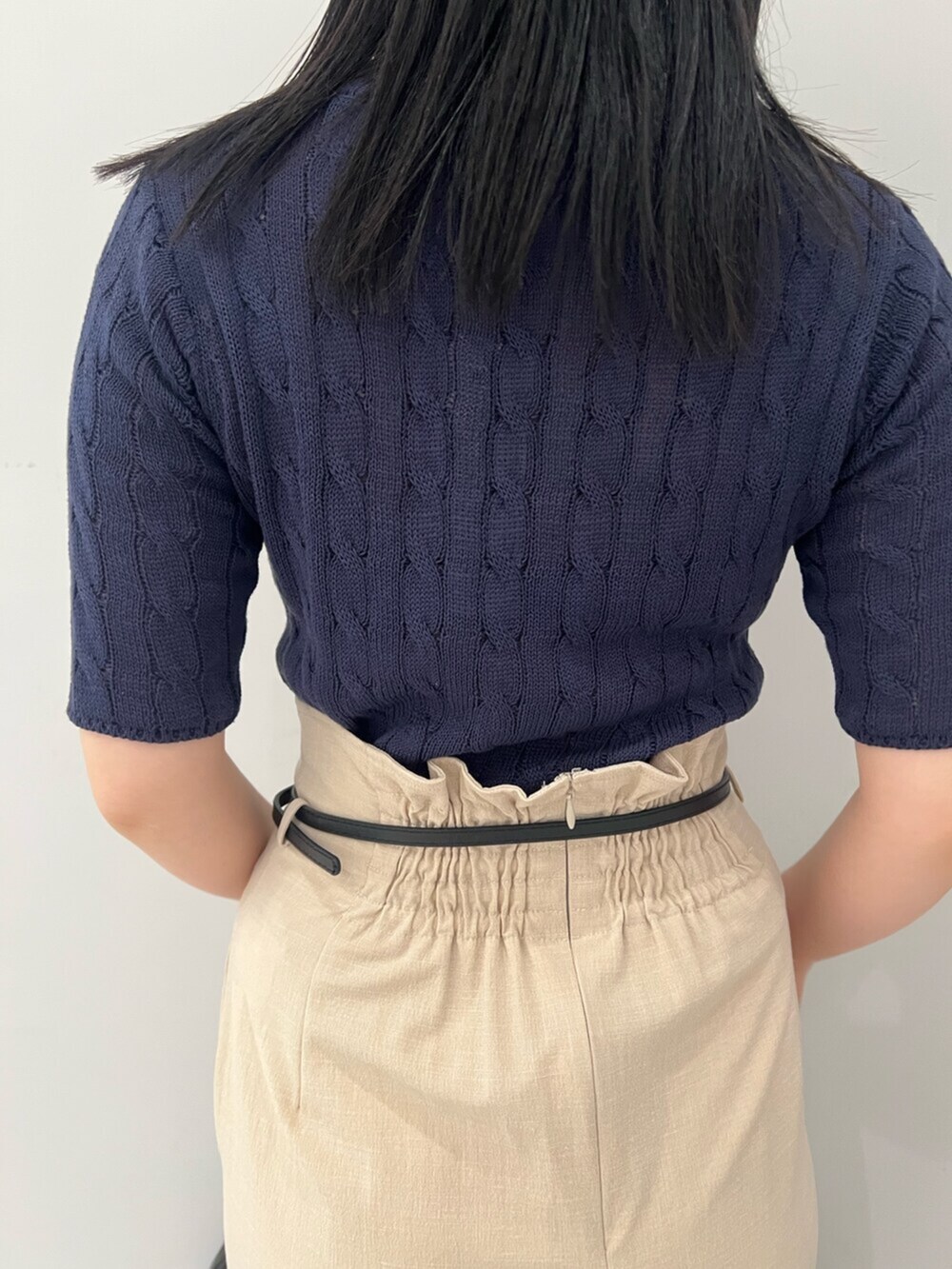 ブルー系のニット/セーター、ホワイト系のサンダル、ベージュ系のスカートを着用したレディースの春コーディネートの6枚目の写真